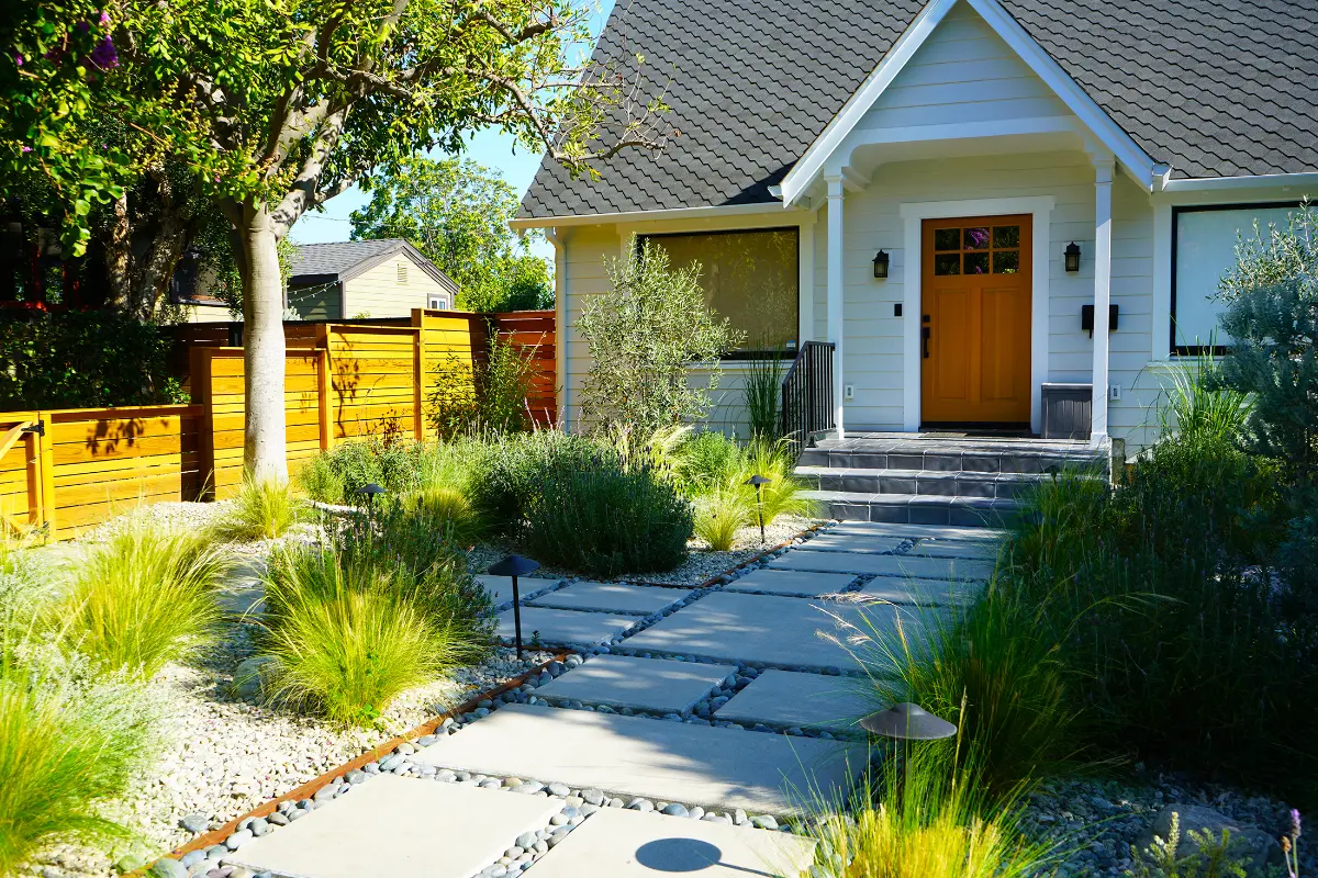 Front yard with grasses, stone pavers and cedar horizontal fence