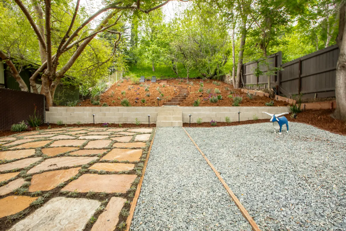 Flagstone patio with gravel yard and terraced hillside planting